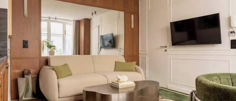 A modern living room with a sofa, a coffee table, and a television.