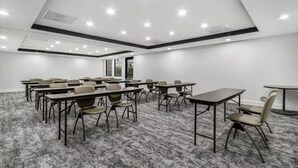 A conference room with multiple tables and chairs, a carpeted floor, and recessed ceiling lighting. - Accessible 2BR Suite | Roll Shower & Hot Breakfast (Maumee)