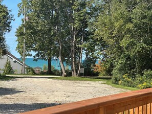 A gravel driveway leading to a wooden deck overlooking a body of water, with a gazebo and a private property sign visible. - Maitland Inlet Cottage — Where Goderich Sunsets, Beach Days, and Waterviews Meet (Goderich)