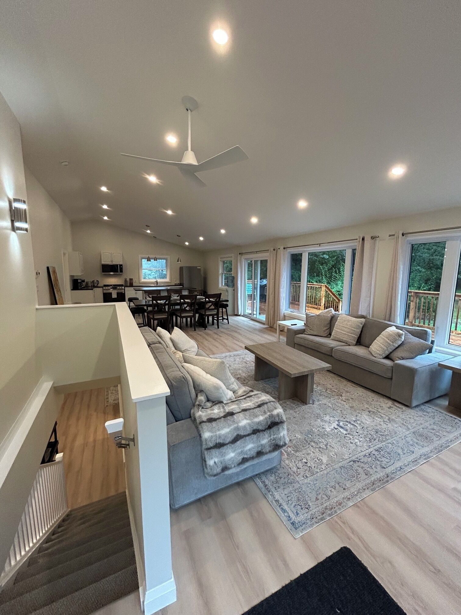 A spacious living room with a sofa set, a coffee table, and a dining area with chairs.