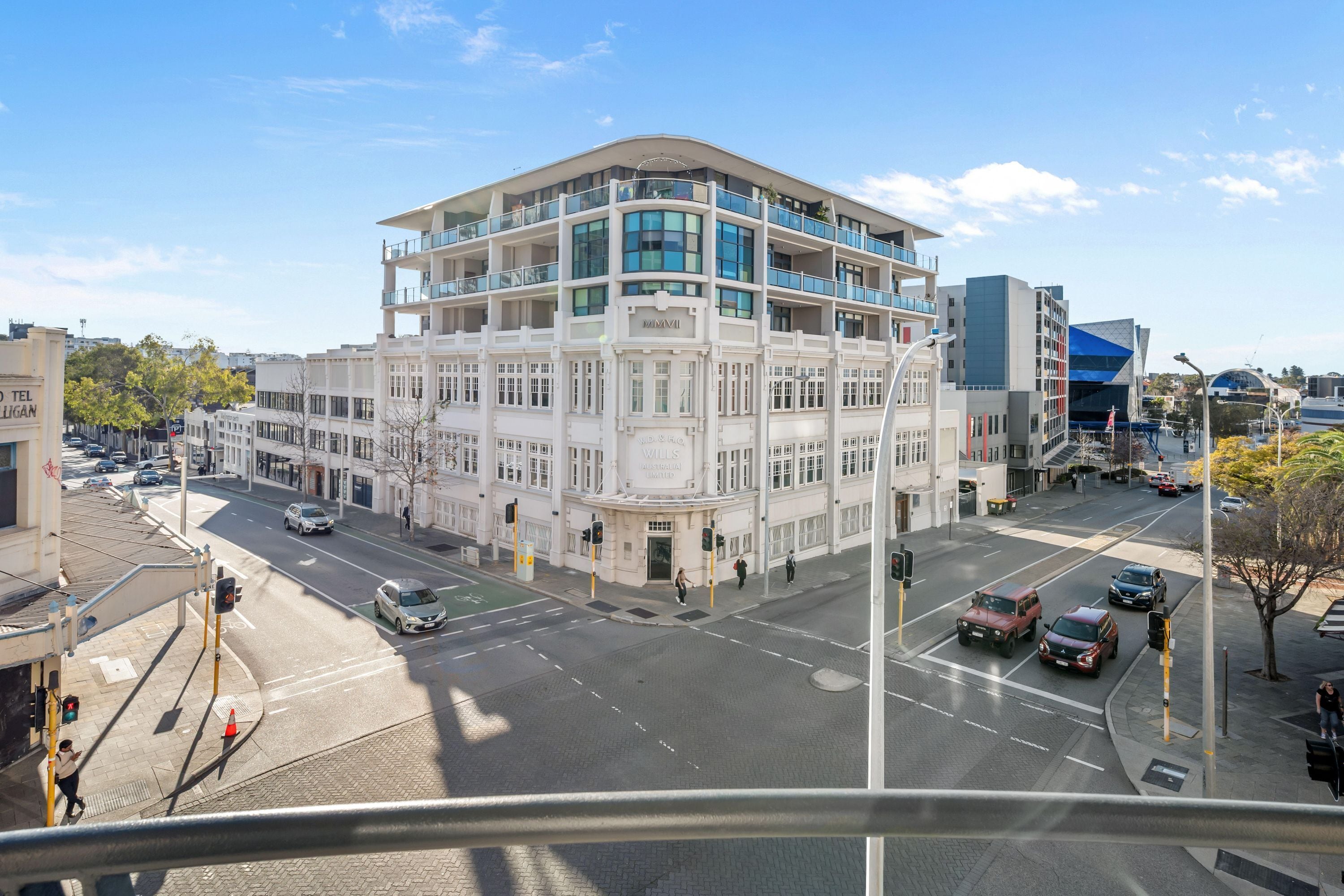 A multi-story building with a prominent entrance and a balcony on the upper floors.
