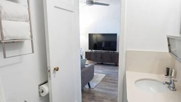 Un baño con inodoro, lavamanos y toallero.