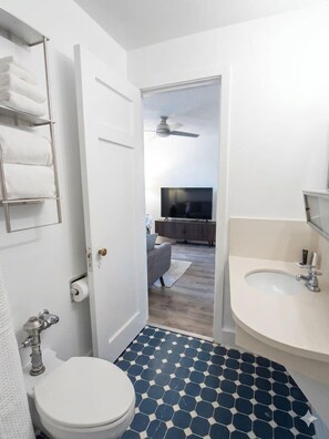 Ein Badezimmer mit Toilette, Waschbecken und Handtuchhalter.