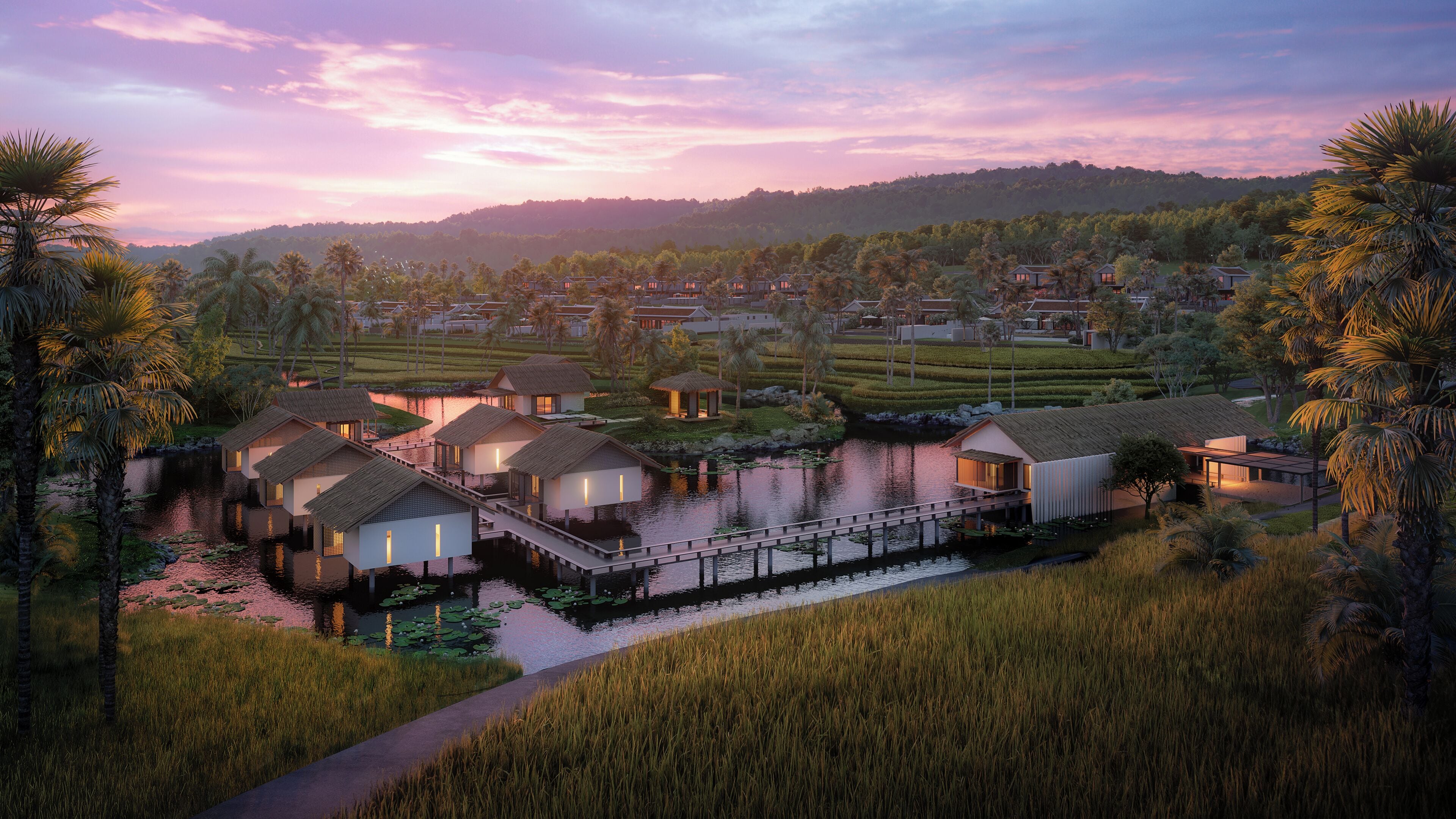 A resort with overwater bungalows connected by walkways, a lake, and a hilly landscape.