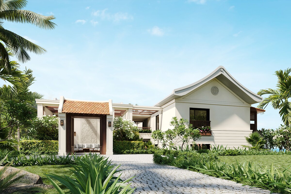 A modern building with a traditional roof, surrounded by lush greenery and palm trees.