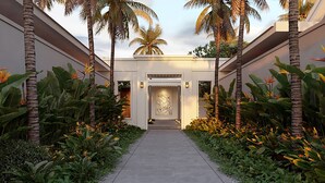 A pathway leading to a building entrance with palm trees and tropical plants on either side. - Park Hyatt Phu Quoc (Phu Quoc)