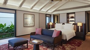 A hotel room with a bed, a sofa, a small table, and a large window. - Park Hyatt Phu Quoc (Phu Quoc)