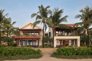 A two-story resort with a covered outdoor seating area, a pool, and lush landscaping. - Park Hyatt Phu Quoc (Phu Quoc)
