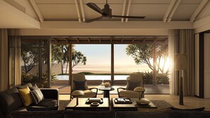 A modern living room with a large window overlooking a beach, furnished with sofas and a coffee table. - Park Hyatt Phu Quoc (Phu Quoc)