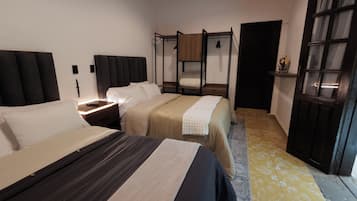 Una habitación de hotel con dos camas, una mesita de noche, un armario y una puerta con paneles de vidrio.