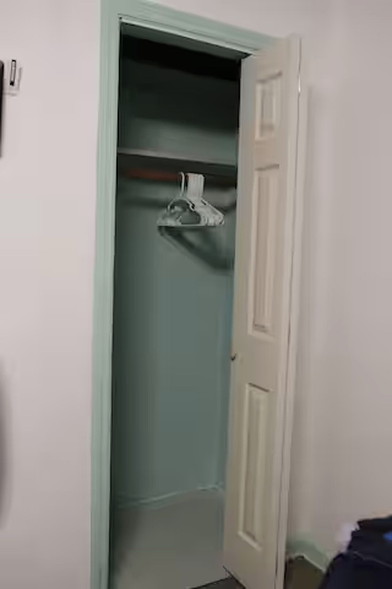 Un armario con barra para colgar y una puerta.