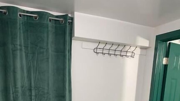 Een badkamer met douchegordijn, handdoek en stoel.