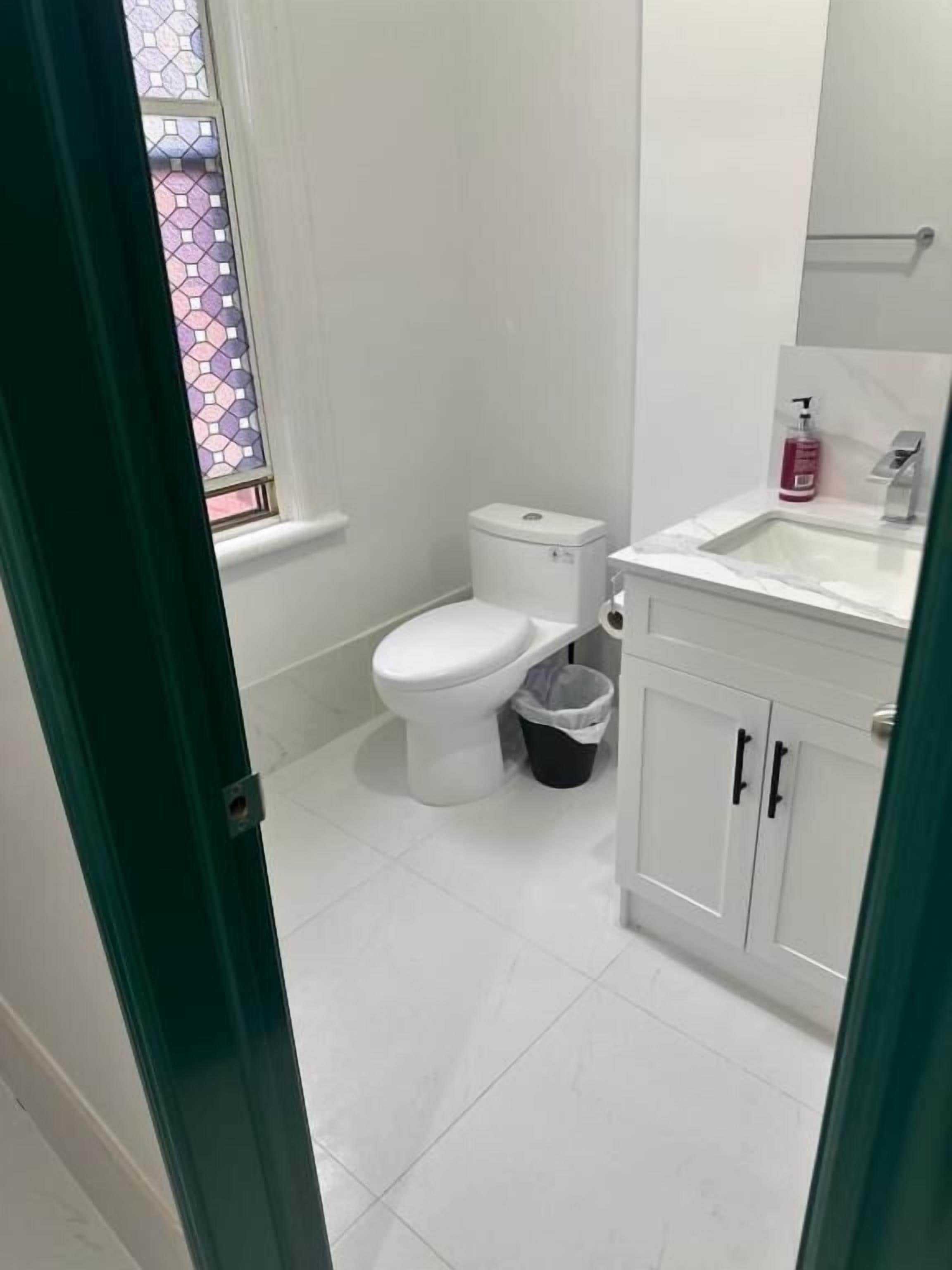 Un baño con inodoro, lavabo y un cubo de basura.