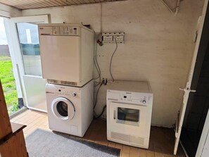 A laundry room with stacked appliances, a washing machine, and a dryer. - 2 Person Holiday Home in Vra (Vra)