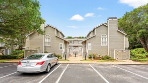 A two-story building with a central entrance, parking lot, and a car parked in front. - Cumberland Terrace 2E (Myrtle Beach)