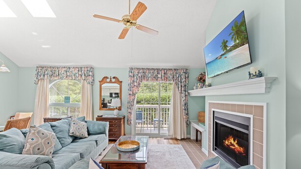 A living room with a sofa, a fireplace, a television, and a ceiling fan. - Cumberland Terrace 2E (Myrtle Beach)