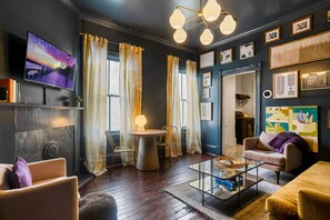 A modern living room with a television, a round table, and a sofa. - 2 bed/1 bath, Walkable to Forsyth, Historic (Savannah)