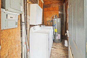 Ein kleiner Hauswirtschaftsraum mit Waschmaschine, Trockner und Warmwasserbereiter.