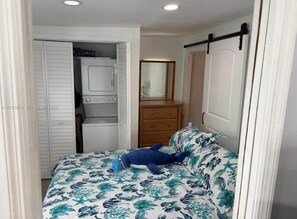 Ein Schlafzimmer mit einem Bett, einem Schminktisch, einem Spiegel und einem Kleiderschrank.