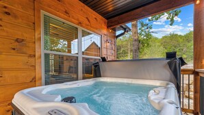 A hot tub on a wooden deck with a view of trees and a clear sky. - Oak-Zarks Getaway - Cabin w/ 2 King Suites, Hot Tub, Fire Pit + Resort Amenities (Hollister)