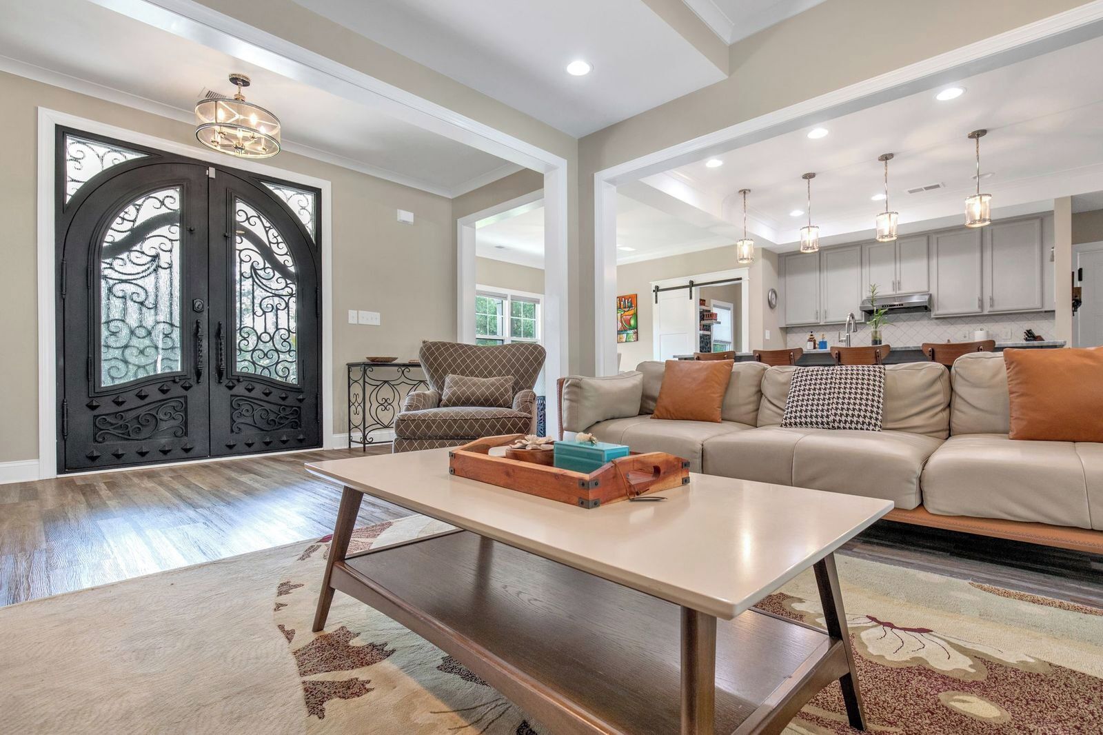 A spacious living room with a sofa, a coffee table, and a decorative door.