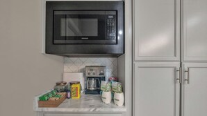 A kitchen with a built-in microwave, coffee maker, and various kitchen items on the counter. - Luxury pro golf & equestrian retreat with pool and gym. Peaceful retreat 6BD/4BR (Carthage)