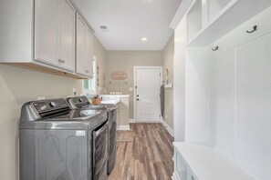 Un cuarto de lavandería con lavadora, secadora y lavabo.