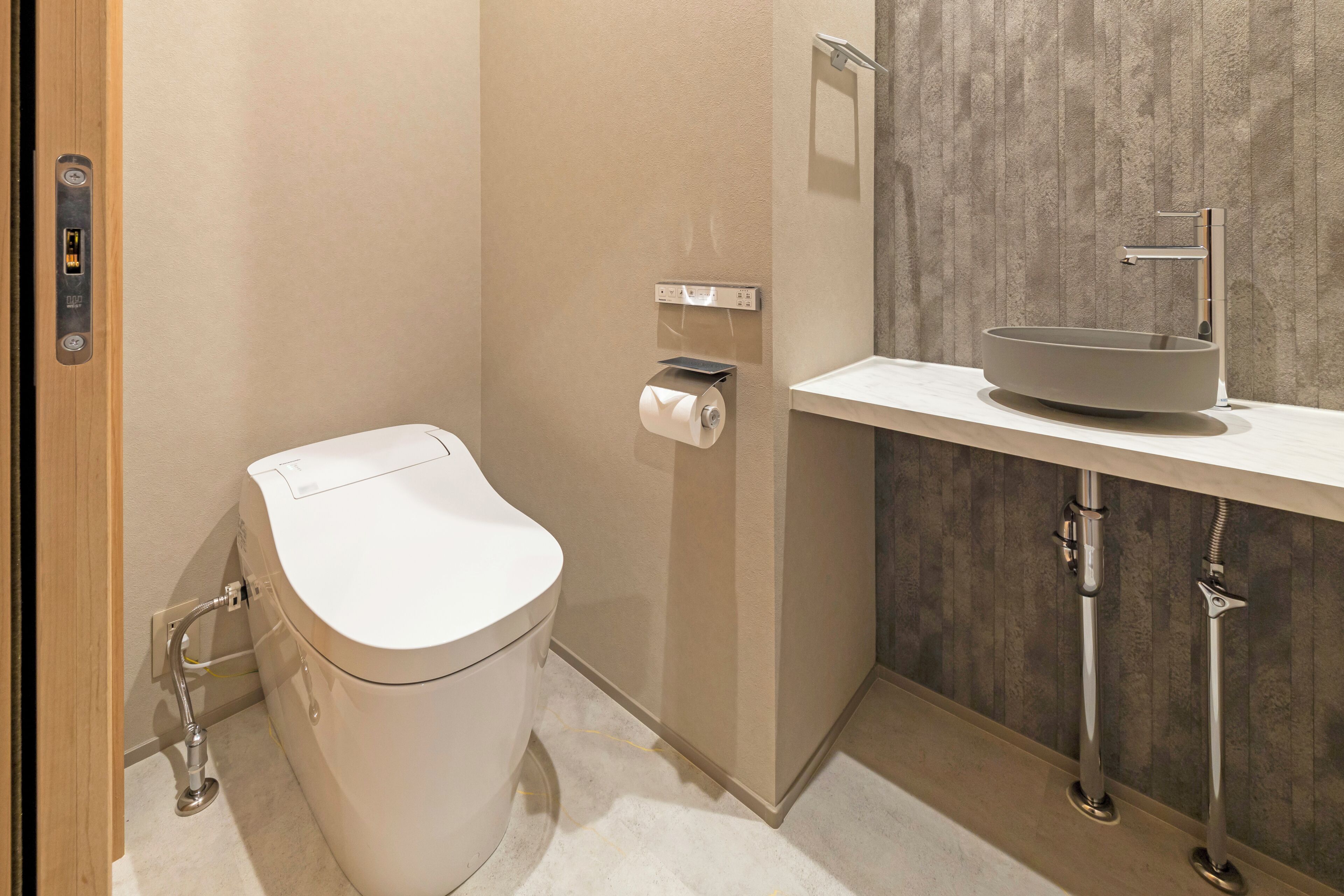 A modern bathroom with a toilet, sink, and shower.