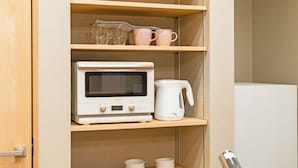 A kitchen with a microwave, a coffee maker, and a refrigerator.