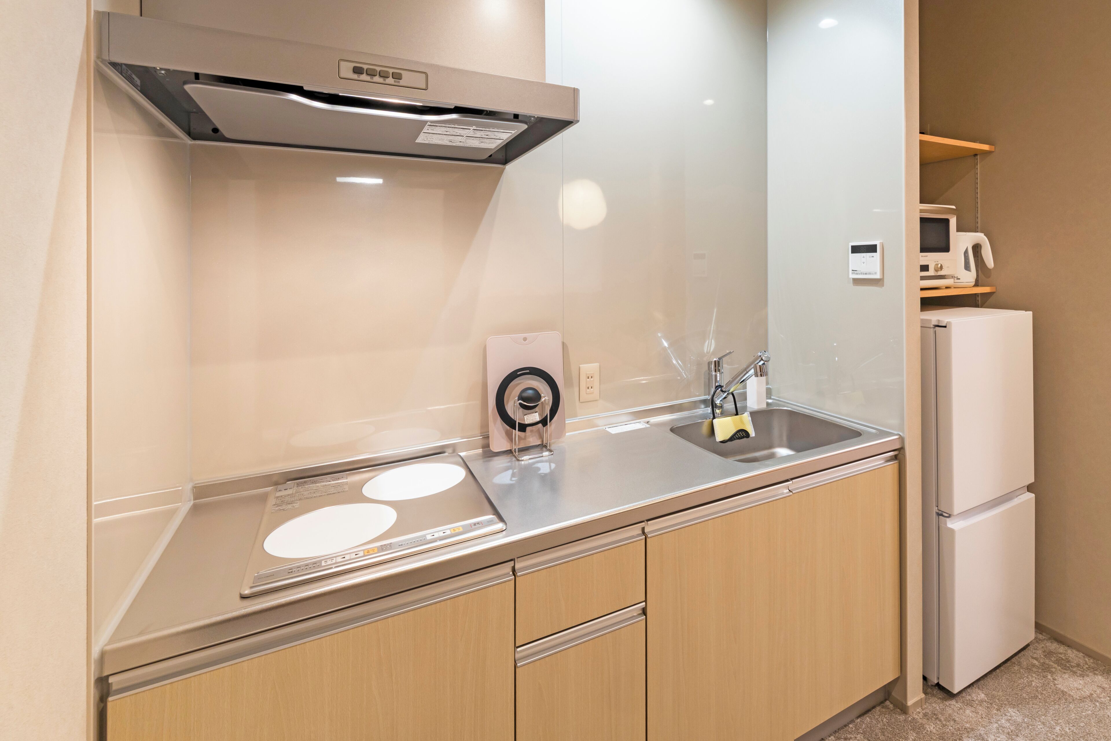 A modern kitchen with stainless steel appliances, a built-in oven, and a microwave on a shelf.