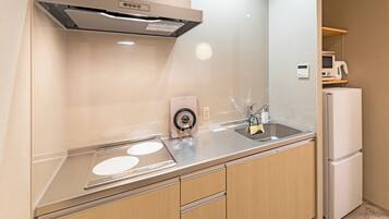 A modern kitchen with stainless steel appliances, a built-in oven, and a microwave on a shelf.