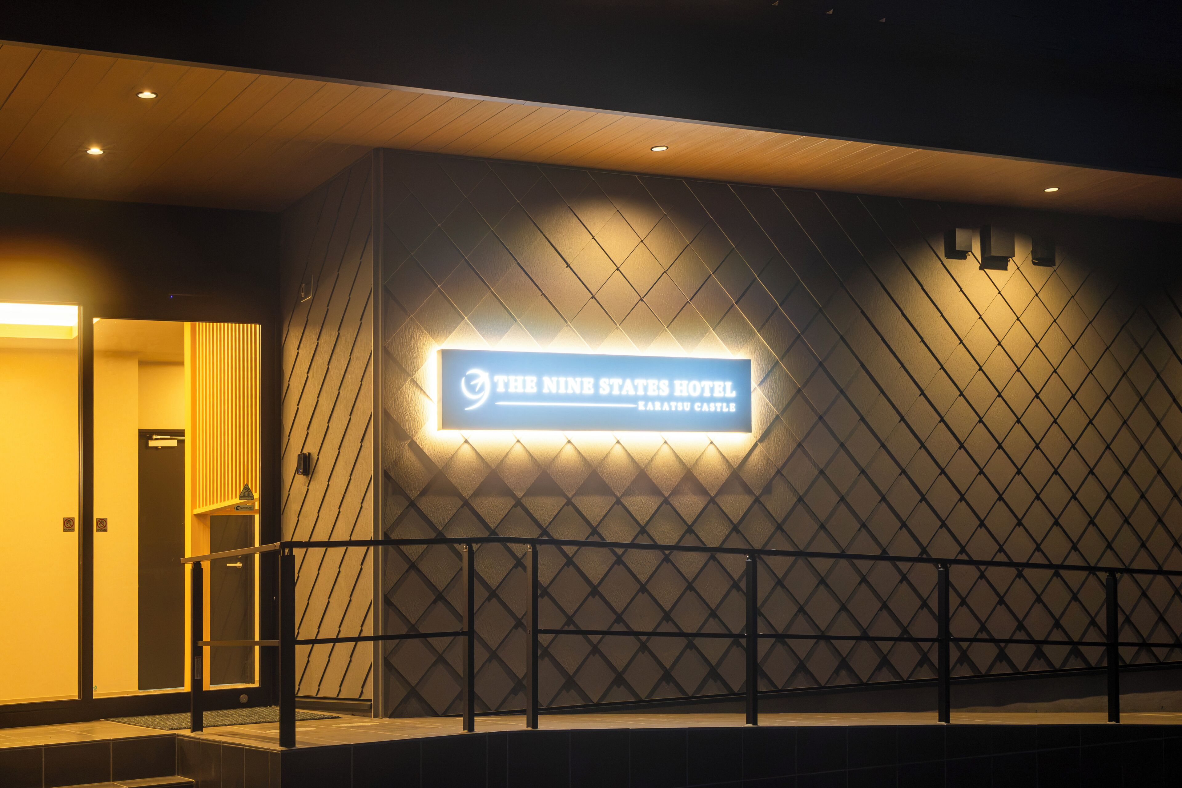 A hotel entrance with a sign for 'The Nine States Hotel Karatsu Castle'.