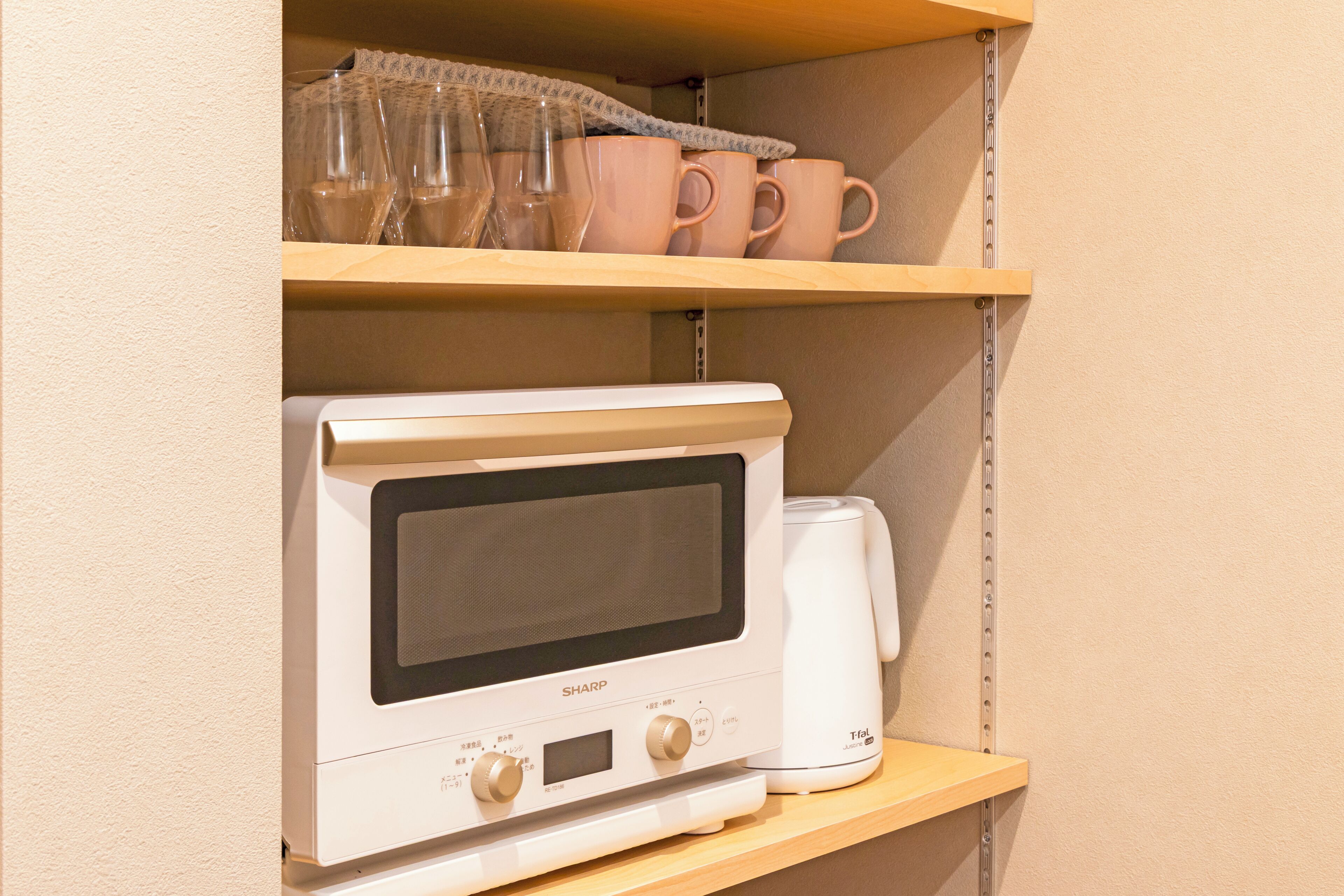 Un four à micro-ondes est posé sur une étagère, avec une machine à café à côté.