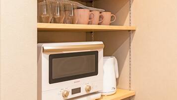 Un four à micro-ondes est posé sur une étagère, avec une machine à café à côté.