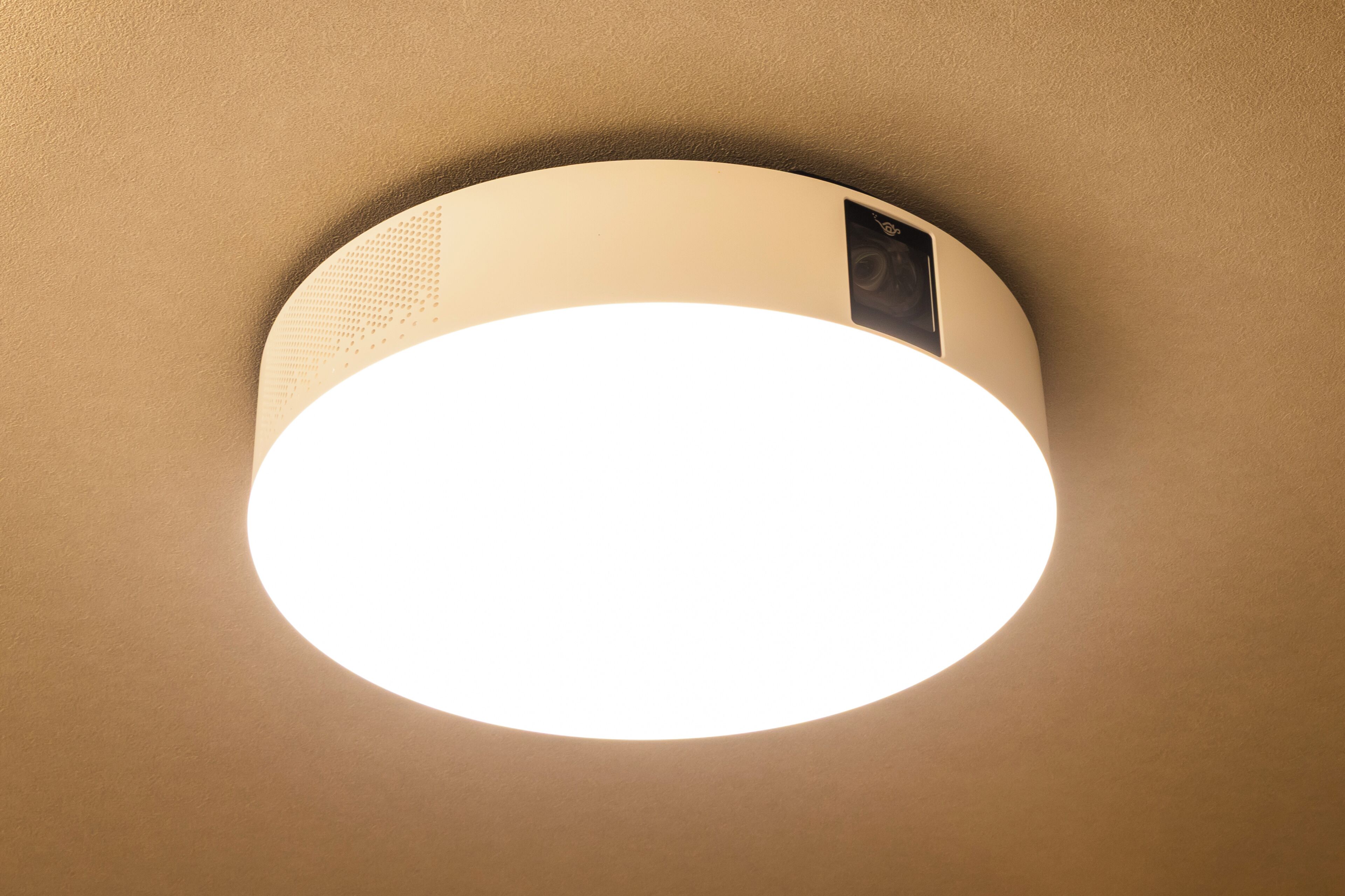 Una lámpara empotrada en el techo con un diseño circular y un panel de control visible.