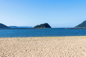 Uma praia com areal e mar calmo.