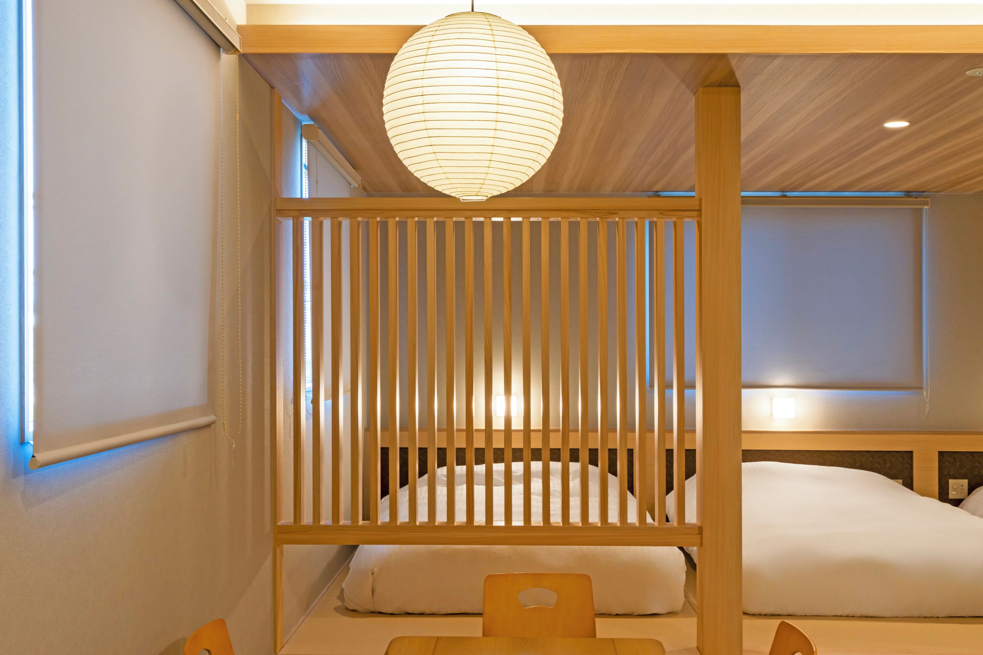 A room with a bed, a wooden partition, and a hanging light fixture.
