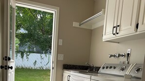 Eine Küche mit Backofen, Spüle und einer Tür zu einer Terrasse.