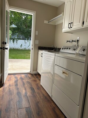 A kitchen with a built-in oven, a sink, and a door leading to a patio.
