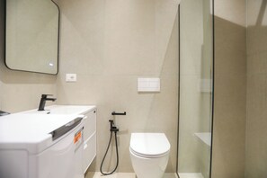 A bathroom with a white sink, mirror, and toilet. - Palm Olive Studio (Orikum)
