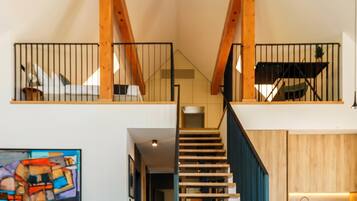 A staircase with wooden railings leading to a second-floor balcony.