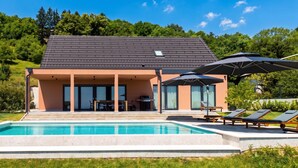 A modern house with a swimming pool, outdoor seating, and a covered patio. - Vineyard Panorama Villa With Pool And Sauna (Jastrebarsko)