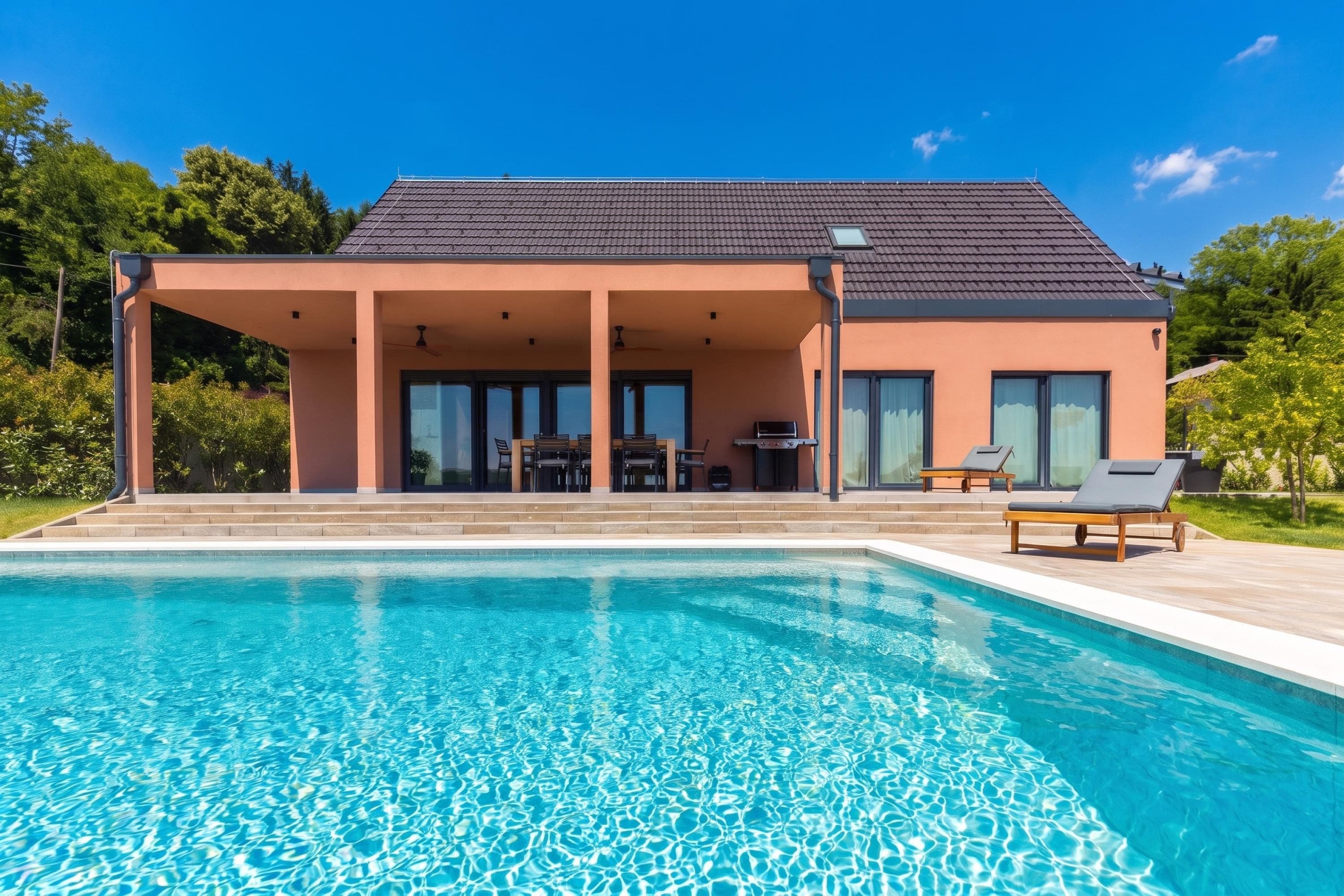 A modern house with a swimming pool, covered patio, and outdoor furniture.