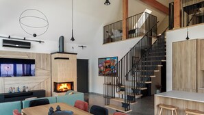 A modern interior with a fireplace, a dining area, and a staircase. - Vineyard Panorama Villa With Pool And Sauna (Jastrebarsko)