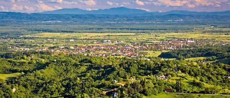 A panoramic view of a town nestled in a valley with surrounding hills and a clear sky.