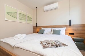 A neatly made bed with white linens, a magazine, and rolled towels on the bed. - Vineyard Panorama Villa With Pool And Sauna (Jastrebarsko)