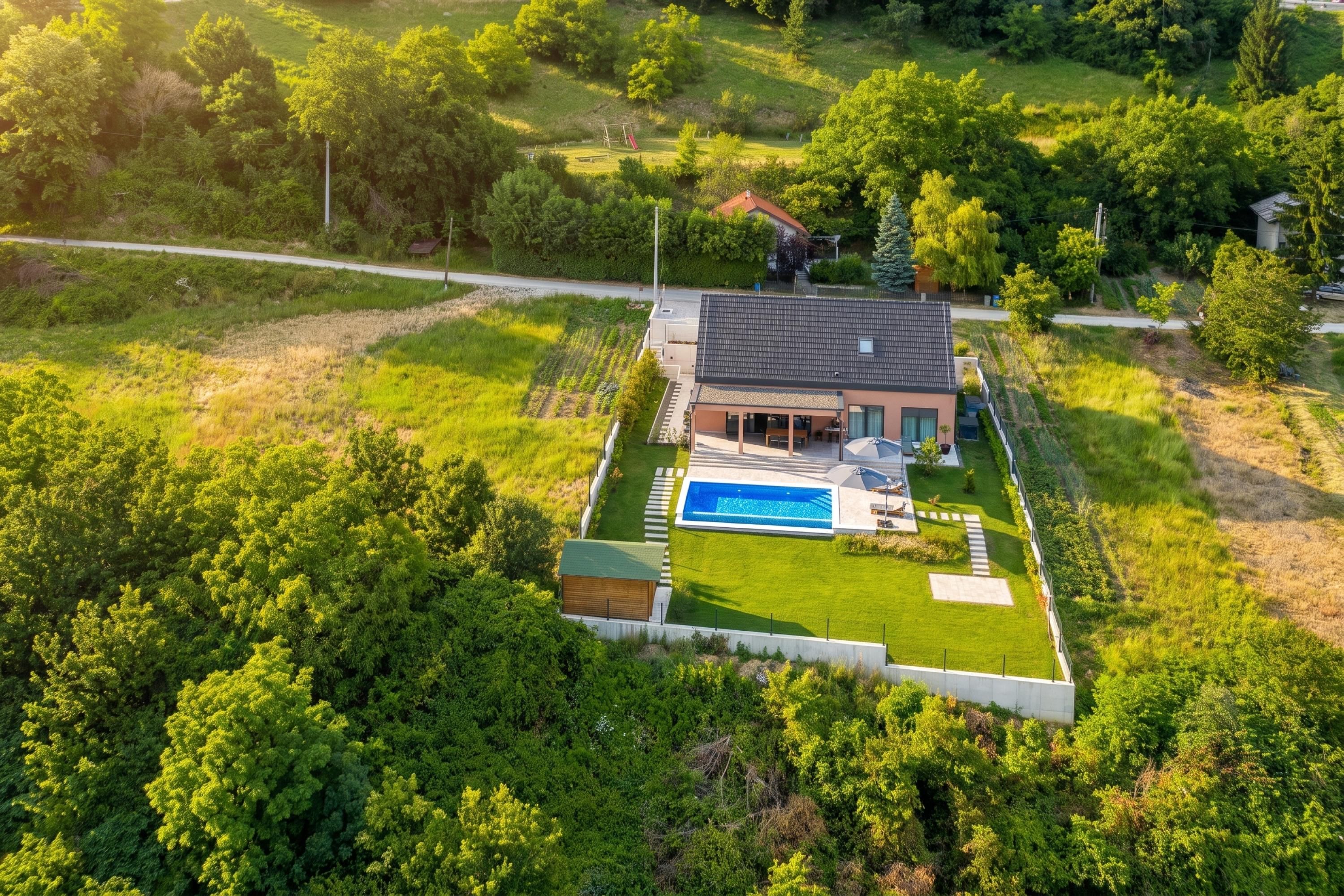 Une maison moderne dotée d’une piscine, entourée d’une végétation luxuriante et d’une pelouse bien entretenue.