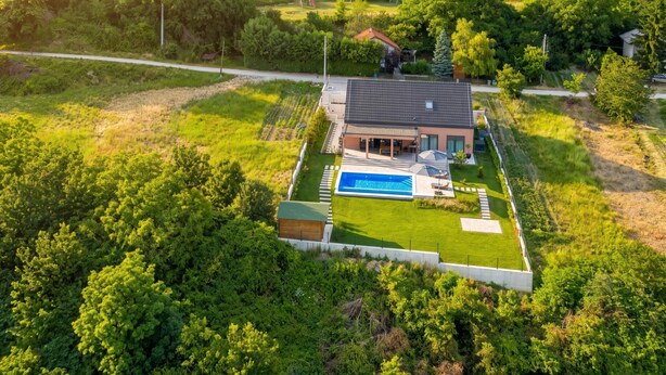 A modern house with a swimming pool, surrounded by lush greenery and a well-maintained lawn. - Vineyard Panorama Villa With Pool And Sauna (Jastrebarsko)