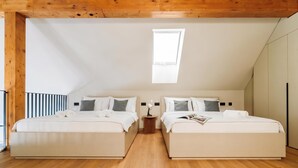 A bedroom with two beds, a skylight, wooden beams, and a striped wall. - Vineyard Panorama Villa With Pool And Sauna (Jastrebarsko)