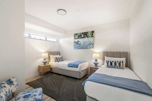 Ein modernes Hotelzimmer mit Bett, Nachttischen, einem Fenster und einem Bild an der Wand.